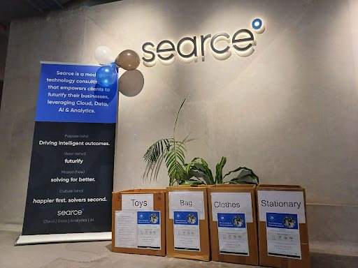 Boxes labelled toys, bags, clothes and stationery next to a Searce standee